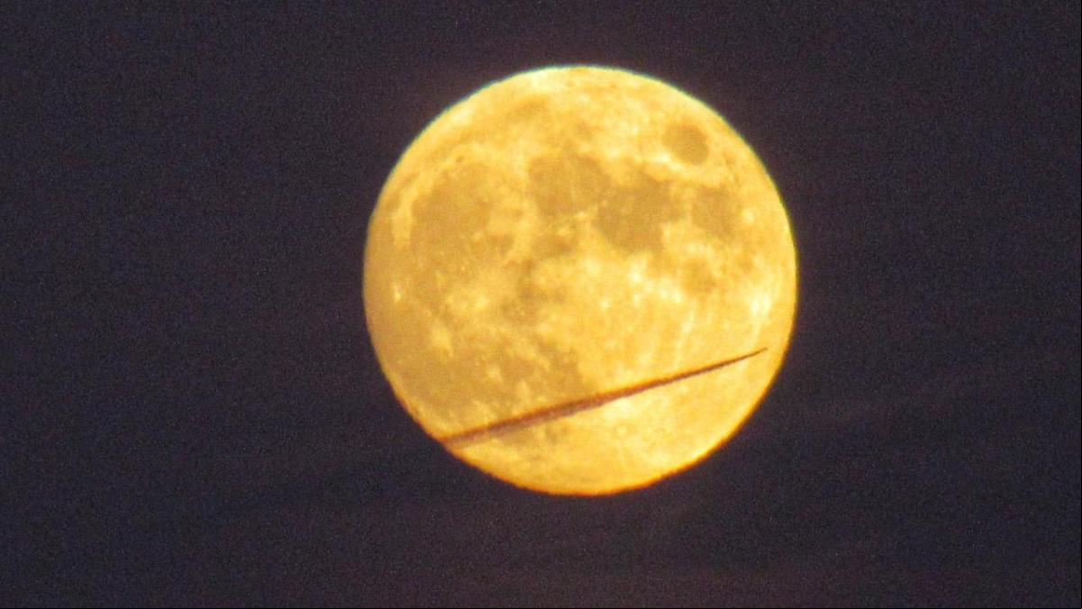 Un avión atraviesa la luna llena del castor
