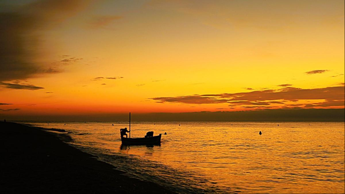 La barca que se avanza a la salida del sol