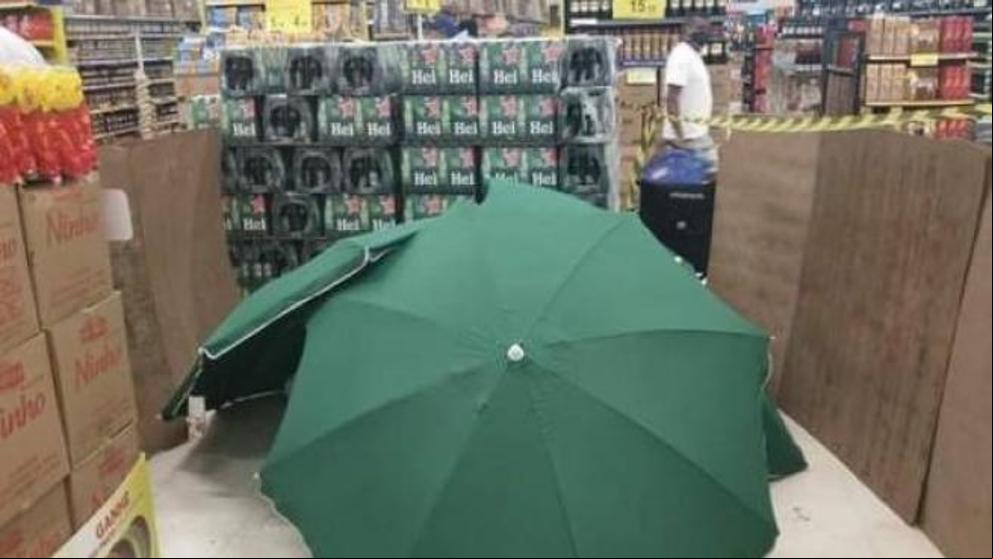 Un hombre muere y tapan su cadáver con varias sombrillas en un supermercado