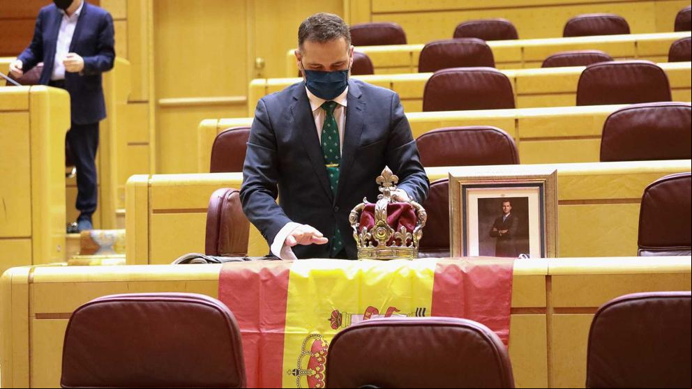 Un senador del PP recibe a Iglesias con la bandera de España, una corona y una foto del Rey